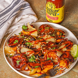  Sweet potatoes glazed in maple syrup and Yellowbird Organic Sriracha, topped with nuts, pickled ginger, cilantro, cooked in a skillet and served with a squeeze of fresh lime juice.