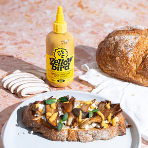 Savory toast topped with a mushroom medley, cottage cheese, a drizzle of Yellowbird Garlic Shiitake Hot Sauce, and fresh sprouts on toasted sourdough.